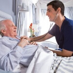 אדם חולה בדלקת כרונית של הקיבה שוכב במיטת בית חולים ורופא בודק אותו